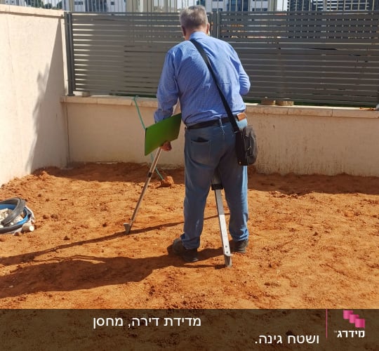 מודד בשטח עם ציוד מדידה על אדמה